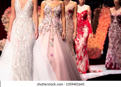 Female models walk the runway in different dresses during a Fashion Show. Fashion catwalk event showing new collection of clothes.