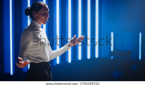 Female\
Motivational Speaker on Stage, Talking about Happiness, Diversity,\
Success, Leadership, STEM and How to Be Productive. Woman Presenter\
Leads Tech Business Conference. Low Angle\
Portrait