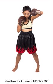 Female Muay Thai fighter posing on white background. A woman stands ready to fight Muay Thai. Attack of Asian Girl in boxing gloves. Asian Muay Thai isolated on white background.