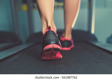 Female Muscular Feet In Sneakers Running On The Treadmill At The Gym. Concept For Fitness, Exercising And Healthy Lifestyle.