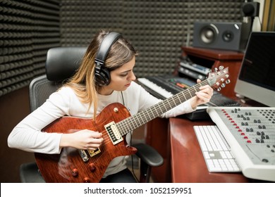 Female Musician Playing Guitar In Recording Studio Room  Composing Music