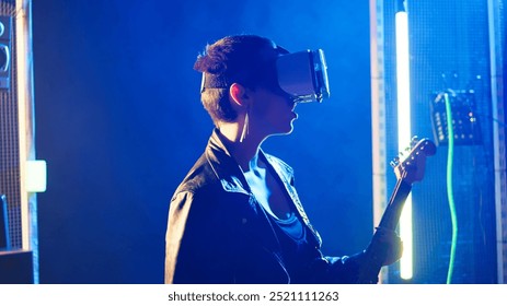 Female musician using virtual reality headset during live show at nightclub, playing her electric guitar and wearing vr glasses. Woman rock star in leather does thrash metal. Camera A. - Powered by Shutterstock