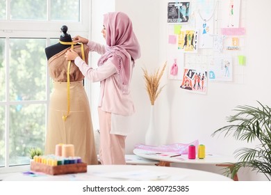 Female Muslim fashion designer working in studio - Powered by Shutterstock