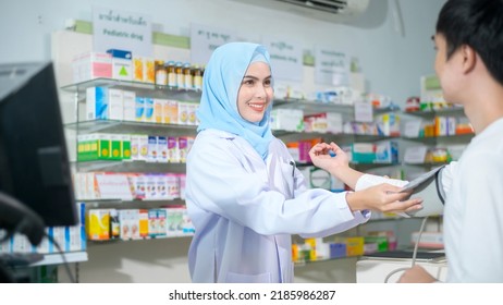 A Female muslim pharmacist counseling customer about drugs usage in a modern pharmacy drugstore. - Powered by Shutterstock