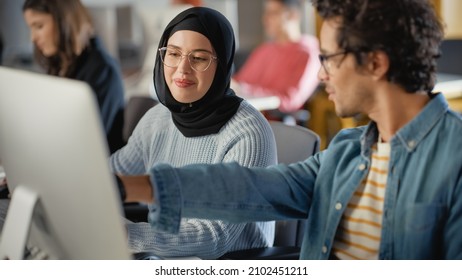 Female Muslim Student Wearing Hijab, Studying in Modern University with Diverse Multiethnic Classmates. She Asks Scholar a Question in College Room. Learning Software Engineering or Computer Science.