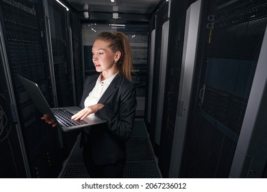 Female IT network manager working in server room