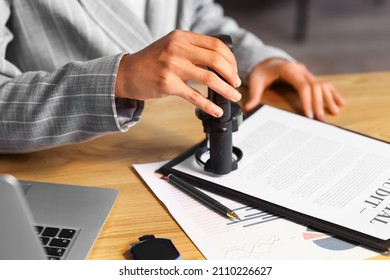 Female notary public attaching seal to document in office, closeup - Shutterstock ID 2110226627