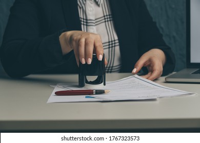 Female notary stamping agreement, company secretary, official document, validity - Shutterstock ID 1767323573