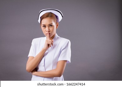 female nurse asking for silence, portrait of asian woman nurse with shhh hand gesture for no noise, silence rule