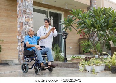 Female nurse assisting a senior man in a wheelchair