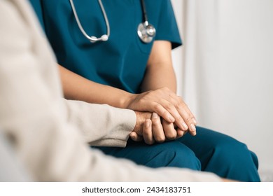 A female nurse caregiver holds hands to encourage and comfort an elderly woman. For care and trust in nursing homes for people of retirement age Caregiver helping elderly woman provides medical advice - Powered by Shutterstock