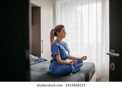 Female nurse or doctor enjoying free time at home after work, meditating. Work-life balance for a healthcare worker.