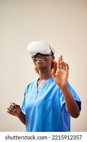 Female Nurse Or Doctor In Scrubs With VR Headset Interacting With AR Technology