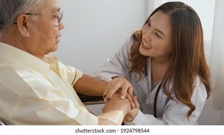 Female Nurse Doctor Wear White Uniform Holding Hand Of Patient Senior Or Elderly Old Man During Sit On Wheelchair Encourage And Empathy At Nursing Hospital, Older People Healthcare Support Concept