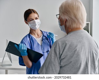 Female Nurse With Documents Otoscope Gloves Medical Mask And Elderly Patient Covid Passport