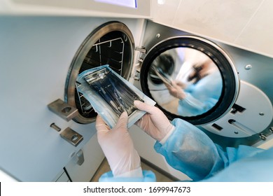 Female nurse doing sterilization of dental medical instruments in autoclave. Sterilization department at dental clinic - Shutterstock ID 1699947673