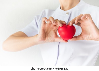 Female Nurse Is Holding A Red Heart Shape. Health, Insurance And Love Concept