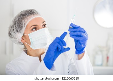 Female nurse holding syringe for injection in hospital