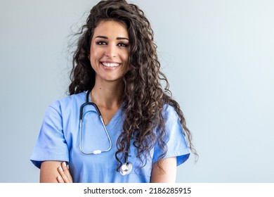 Female nurse looking towards camera, wearing blue scrubs, arms crossed. Medical professional working in hospital. Attractive female doctor at work. Portrait of adult female healthcare professional  - Powered by Shutterstock