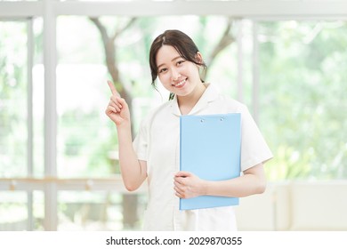 Female Nurse Pointing At The Hospital