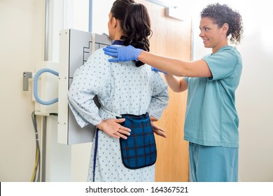 Female Nurse Preparing Patient For Chest Xray In Examination Room