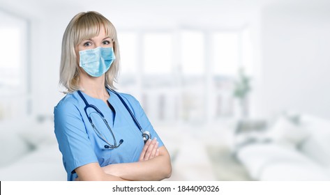 Female Nurse Standing In Blue Clothes With Medical Mask Posing.