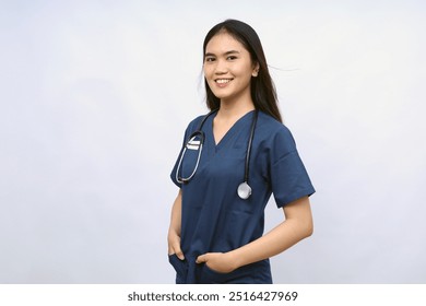 A female nurse is standing wearing scrubs and a stethoscope. He is smiling and looking camera.Portrait of young female nurse isolated on white - Powered by Shutterstock