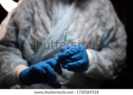 A female nurse with a syringe prepared to inject the vaccine to a patient