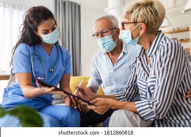 Eine Krankenschwester, die während ihres Besuchs zu Hause mit Patienten im Alter mit Maske spricht, unterzeichnet eine Versicherungspolice für Senioren.