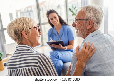 Female nurse talking to seniors patients while being in a home visit, senior couple signs an insurance policy. - Powered by Shutterstock