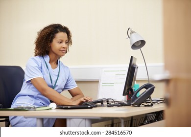 Female Nurse Working At Desk In Office