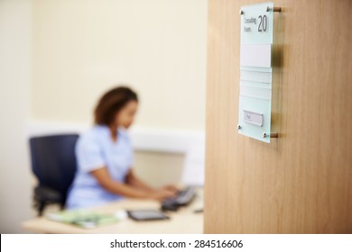 Female Nurse Working At Desk In Office