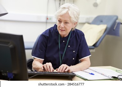 Female Nurse Working At Desk In Office