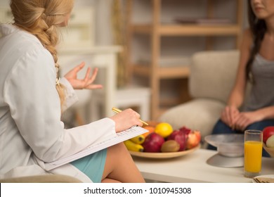 Female nutritionist giving consultation to patient. Making diet plan.