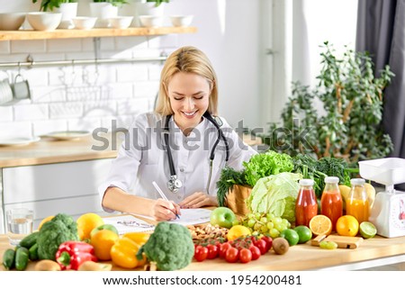Female nutritionist young doctor writing diet plan on table. Right nutrition and slimming concept