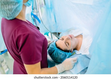 Female octors anesthetist are using tools to anesthesiologist procedures on female patient in the anesthetic machine inside operating room. Cesarean with epidural anesthesia.