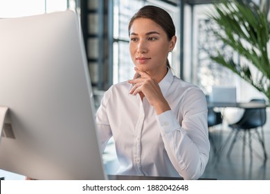 Female Office Manager In White Shirt In Office Interior Background, Beautiful Woman Office Worker. Woman Working With Computer In Big Office, Concept Of Work