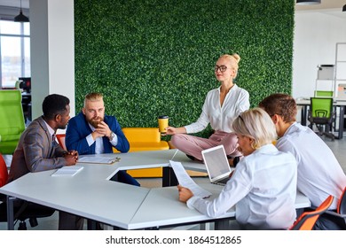 female office worker is meditating, taking break at work for mental balance while others work. mindful businesswoman feeling relief and no stress doing yoga at work ignoring avoiding stressful job - Powered by Shutterstock