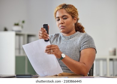 Female Office Worker Stapling Paper Together In Her Office At Work, Being Efficient, Organized And Neat. Young Female Admin Clerk Sorting And Filing Paperwork While Sitting And Working At Her Desk