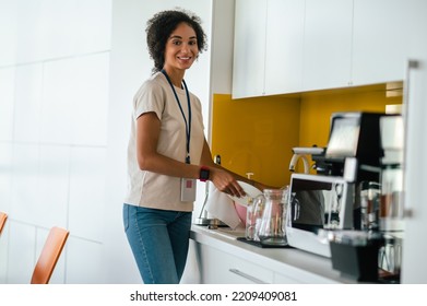 Female Office Worker In The Office Swithing On A Microwave Oven