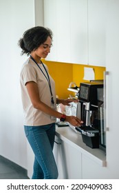 Female Office Worker In The Office Swithing On A Microwave Oven