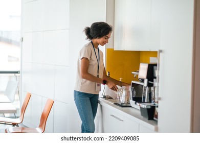 Female Office Worker In The Office Swithing On A Microwave Oven