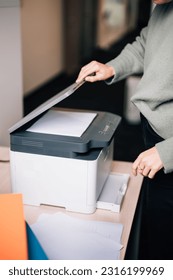 A female office worker using the printer at the office
