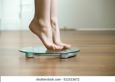 Female On Tiptoes Standing On Glass Floor Weight Scales, Closeup