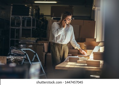 Female online seller confirming orders from customer on the phone. Online web store owner taking order on phone. - Shutterstock ID 1447457045