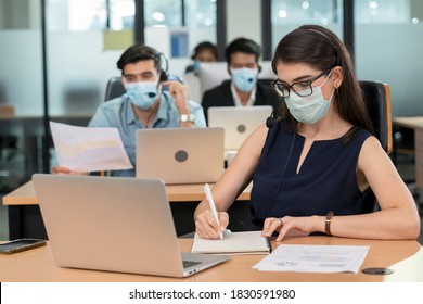 Female operator wears surgical masks to prevent pandemic of the covid-19 coronavirus in a call center. Telemarketer used headset answering customer questions. Security measures of new normal life