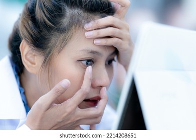 A female ophthalmologist in a ground coat is wearing contact lenses, close-up focusing on face. - Powered by Shutterstock