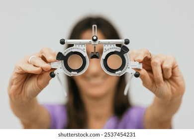 Female optometrist holding trial frame for pediatric eye exam - Powered by Shutterstock