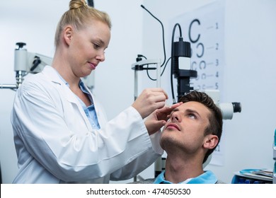 Female optometrist putting eye drop in patient eyes in ophthalmology clinic - Powered by Shutterstock