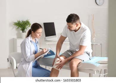 Female orthopedist examining patient with injured knee in clinic - Shutterstock ID 1655501803